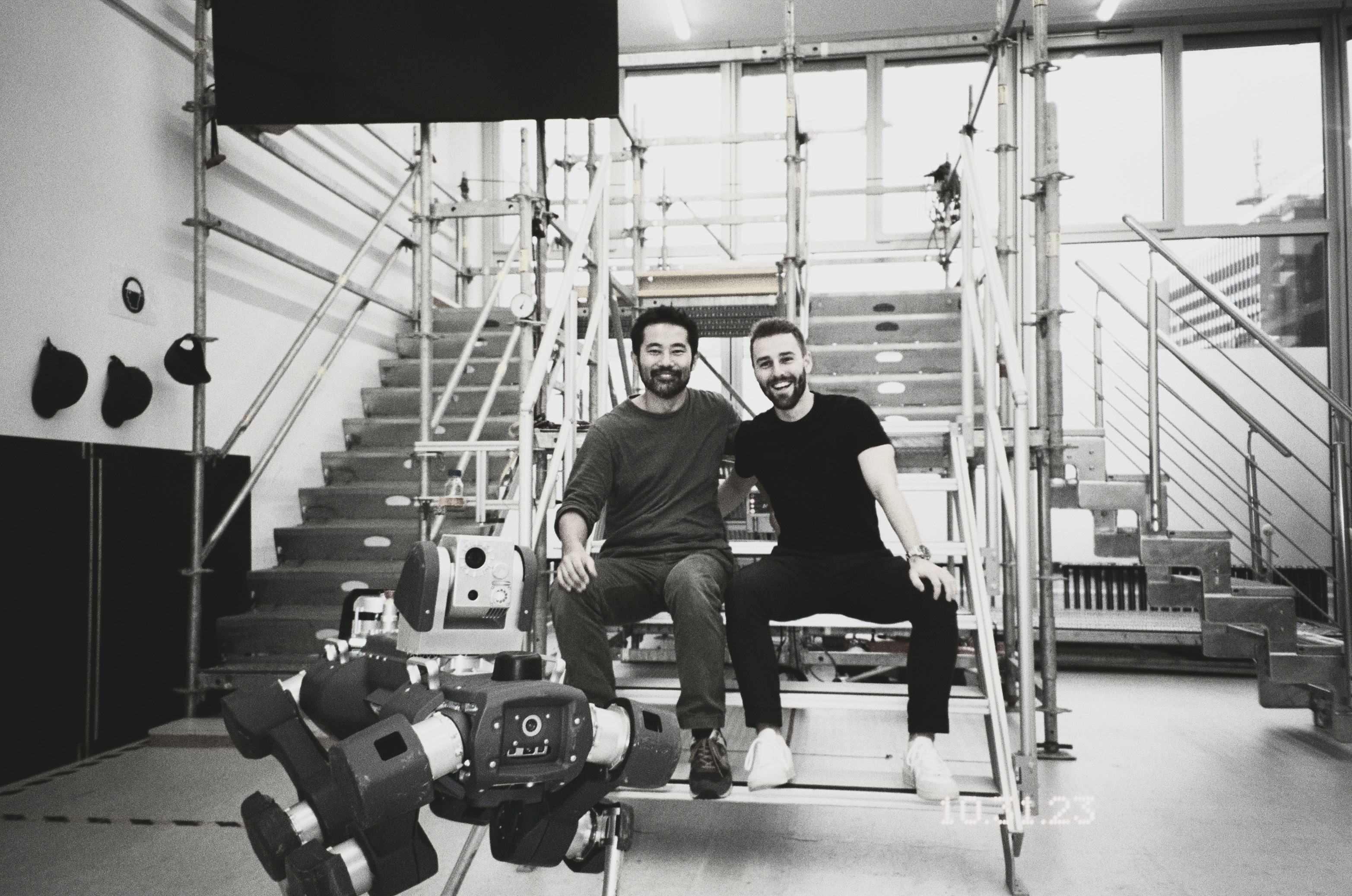 Two engineers seated beside the Anymal X robot